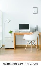 Spacious Room With Wooden Floor With Small Space For Work. By The Wall Wooden Table With Computer