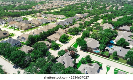 Spacious suburban residential houses with inground swimming pools, large backyard, lush greenery trees in new development neighborhood in Flower Mound near Dallas Fort Worth metroplex, aerial. USA - Powered by Shutterstock