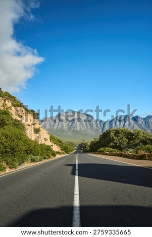 Spacious Thoroughfare Extends Toward Towering Summits Amidst Striking Cerulean Environment Evoking Exploration
