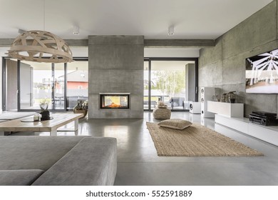 Spacious villa interior with cement wall effect, fireplace and tv - Shutterstock ID 552591889