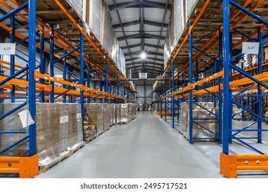 Spacious Warehouse Interior With Tall Racking Systems Displaying Stacked Pallets in Business Environment. Interior of a large warehouse features high racking systems filled with neatly stacked pallet - Powered by Shutterstock