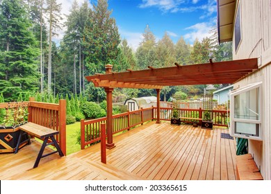 Spacious wooden deck with benches and attached pergola