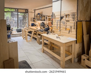 Spacious woodworking studio with tables, frames, tool racks, bright walls, power saws, and crafting stations ready for construction and DIY building.