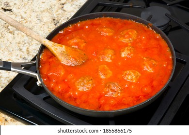 Spagetti Marinara Sauce With Delicious Meatballs Simmering In A Sauce Pan Before Being Added To A Pile Of Pasta.