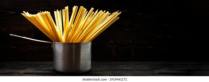 Spagetti Or Spaghetti Or Noodle In Brushed Metal Stewpot Utensil Pot. Cooking Concept Banner. Copy Space Place For Text And Logo 