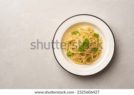 Spaghetti aglio e olio. Traditional Italian pasta with garlic, olive oil and chili peppers in plate on concrete background. Top view, copy space.