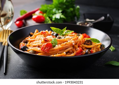 Spaghetti Alla Puttanesca - Italian Pasta Dish With Tomatoes, Black Olives, Capers, Anchovies And Basil. Top View, Flat Lay