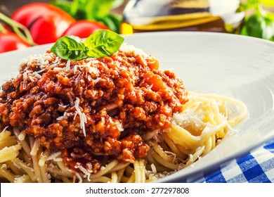 Spaghetti bolognese with cherry tomato and basil on plate.