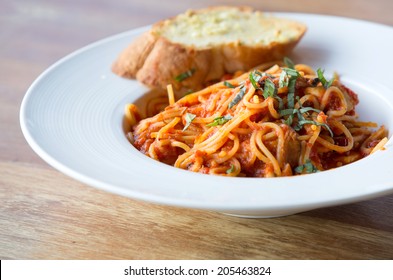 spaghetti bolognese with garlic bread wooden table