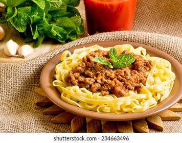 Spaghetti bolognese and mint, garlic, tomato juice on sackcloth - Powered by Shutterstock