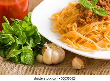 Spaghetti bolognese with mint and tomato juice on sackcloth - Powered by Shutterstock