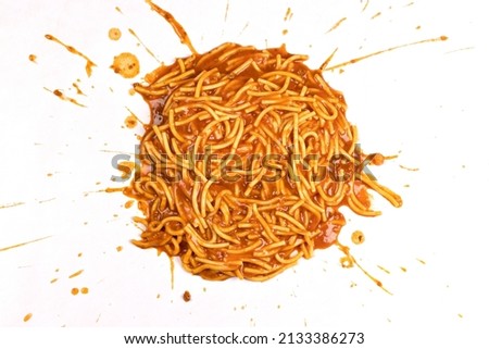 Spaghetti Bolognese splattered on a white background.