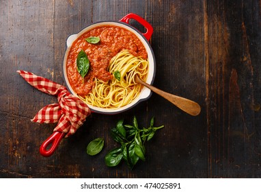 Spaghetti Bolognese With Tomato Sauce And Basil In Iron Pan On Wooden Background
