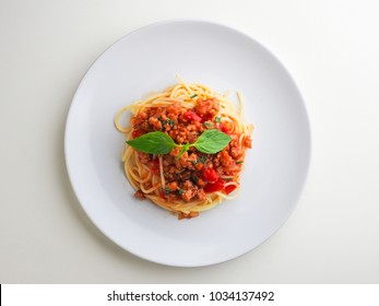 spaghetti bolognese in white dish basil leaf top isolate