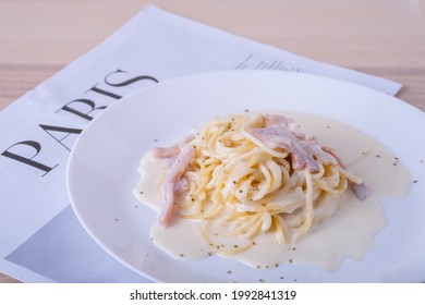 spaghetti carbonara on white plate. spaghetti white cream on wooden table, Italian foodmenu concept with copy space for text. 