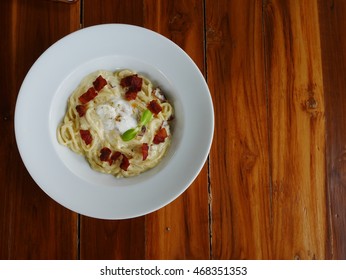 Spaghetti cream sauce with bacon topping egg.