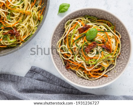 Spaghetti with julienne vegetables, carrots, zucchini, and sun-dried tomatoes. Healthy vegan food. Top view,  copy space.