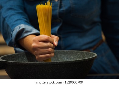 Spaghetti in a kitchen with hand
