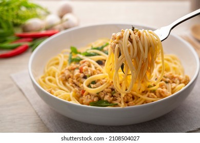 Spaghetti on the fork with stir fried minced chicken and basil,Spicy pasta Pad Kra Pao,Thai fusion food