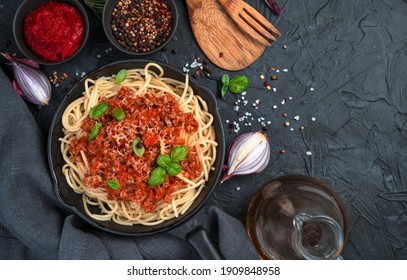 Spaghetti And Pasta Bolognese On A Black Concrete Background. Top View, Horizontal. Cooking Concept.