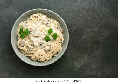 Spaghetti Pasta With Creamy Mushroom Sauce On A Dark Painted Background. Italian Traditional Dish. Top View, Copy Space