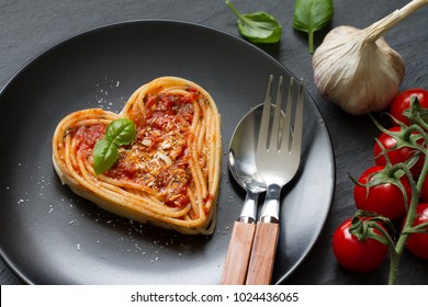 Spaghetti-Nudelherz liebt abstraktes Konzept der italienischen Ernährungsweise auf schwarzem Hintergrund