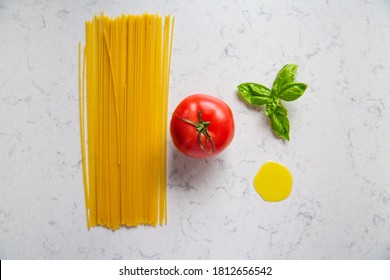 Spaghetti pasta, tomato, fresh basil and yolk on an elegant marble kitchen countertop, top view. - Powered by Shutterstock