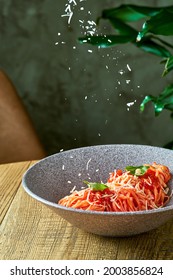 Spaghetti Pasta With Tomato Sauce And Basil In A Gray Plate. Parmesan Cheese Is Falling.