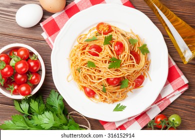 Spaghetti Pasta With Tomatoes And Parsley On Wooden Table. Top View