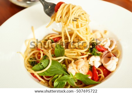 The spaghetti seafood white wine in white dish.close up hand woman eating spaghetti with fork.