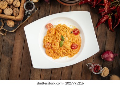 Spaghetti With Shrimp And Tomato Cream Sauce On A Wooden Background