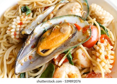 Spaghetti spicy seafood with basil, fusion food Italian gourmet in Thai spicy style. Selective focus on New Zealand mussel.