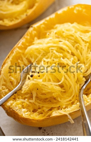 Spaghetti squash baked and pulled apart with two forks, ready to eat on a baking pan