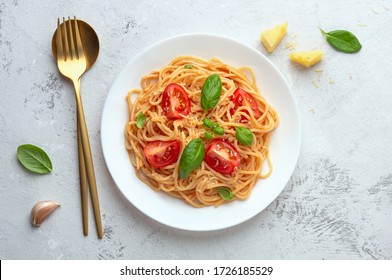 Spaghetti In Tomato Sauce With Cheese On A White Plate On A Light Background. Flat Lay