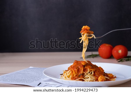 spaghetti tomato sauce on white plate with fork scoop up spaghetti shrimp on wooden table, Italian foodmenu concept with copy space for text. 