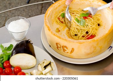 spaghetti with vegetables inside parmesan cheese wheel