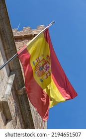 Cáceres Spain - 09 12 2021: View Of The Flag Of The Spanish Monarchy, Hoisted On A Metal Pole, On Display Outside The Facade Of A Public Building, In Cáceres City