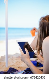 Spain, Europe - 24 June 2017: Busy Woman Using Apple Ipad 2 Smart Computer Device On Sandy Sea Beach Outdoors Background. Back Side View Of Modern Internet Working Person And Blank Display Copyspace
