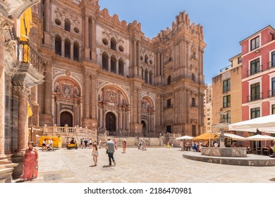 Málaga, Spain, June 10, 2022; View Of The Facade Of The Málaga Cathedral Or Santa Iglesia Catedral Basílica De La Encarnación, With A Fountain And Tourists In The Town Square In The Foreground.