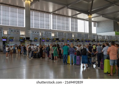 Málaga, Spain, June 16, 2022; Travelers With Suitcases Queuing For Check-in At Malaga Airport Counters.