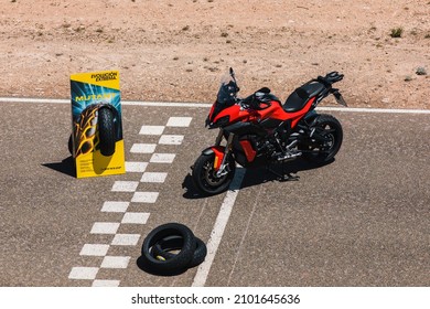 Almería, Spain - May 4th 2021: A red BMW motorbike and Dunlop Mutant Tyres advertisement totem on the circuit finish line, during Dunlop Xperience showroom and test in Almería, Spain.