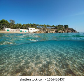 Spain Mediterranean Coast With An Old House On The Beach And Sand Underwater Sea, Costa Brava, Catalonia, Palamos, Split View Over And Under Water Surface