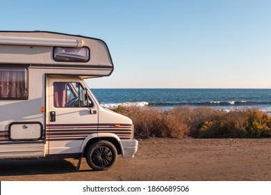 Spain; Nov 2020: Vintage caravan parked in front of the ocean, holidays and freedom feelings, van life. Old campervan ready to sleep in it. Coast of Almería, Mediterranean sea, Andalusia, South Spain