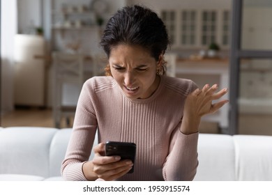 Spam Mailout. Outraged Nervous Young Latina Female Feel Angry Mad Of Spamming In Electronic Messages On Smartphone. Female Customer Dissatisfied Annoyed After Reading Silly Email Marketing Letter Text