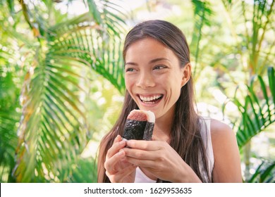 Spam Musubi Rice Ball Sandwich Asian Woman Tourist Eating Japanese Snack Food Typical Of Hawaiian Market In Hawaii.