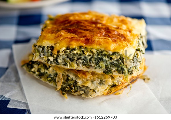 \
Spanakopita. Classic Greek Dish. Layers of\
Phyllo dough, rolled out & brushed with melted garlic butter.\
Filled w/ mixture of spinach, feta cheese, chopped onion, garlic,\
fresh herbs baked to\
golden