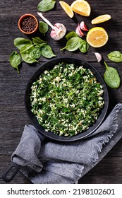 Spanakorizo, Greek Spinach And Rice Pilaf With Lemon, Dill, Spring Onion On A Pan On Dark Wooden Table With Fresh Spinach. Garlic, Vertical View From Above