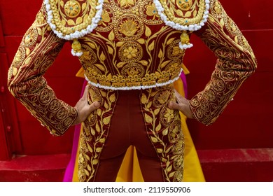 Spanish bullfighter's costume seen from behind in a bullfight. Bullfighting cape in the hands of a matador dressed as a bullfighter.