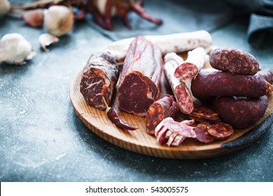 Spanish cured meat, jamon, lomo, chorozo, salchichon and dry peppers, garlic. Charcuterie concept.