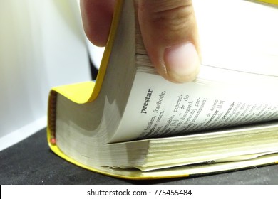 Spanish Dictionary Book In Detail With Fingers Touching It